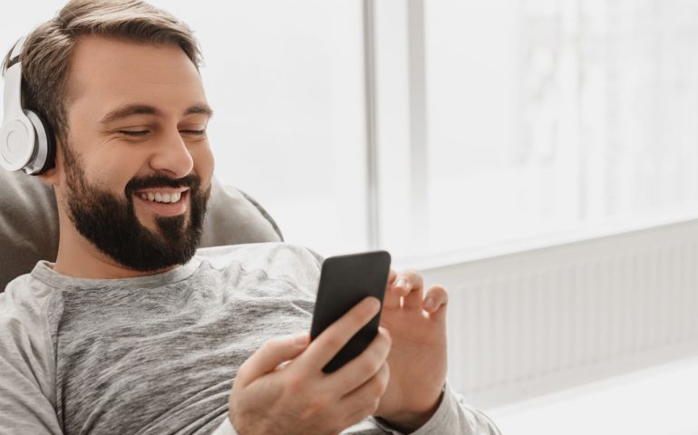 Image of a man on the sofa looking at his smartphone